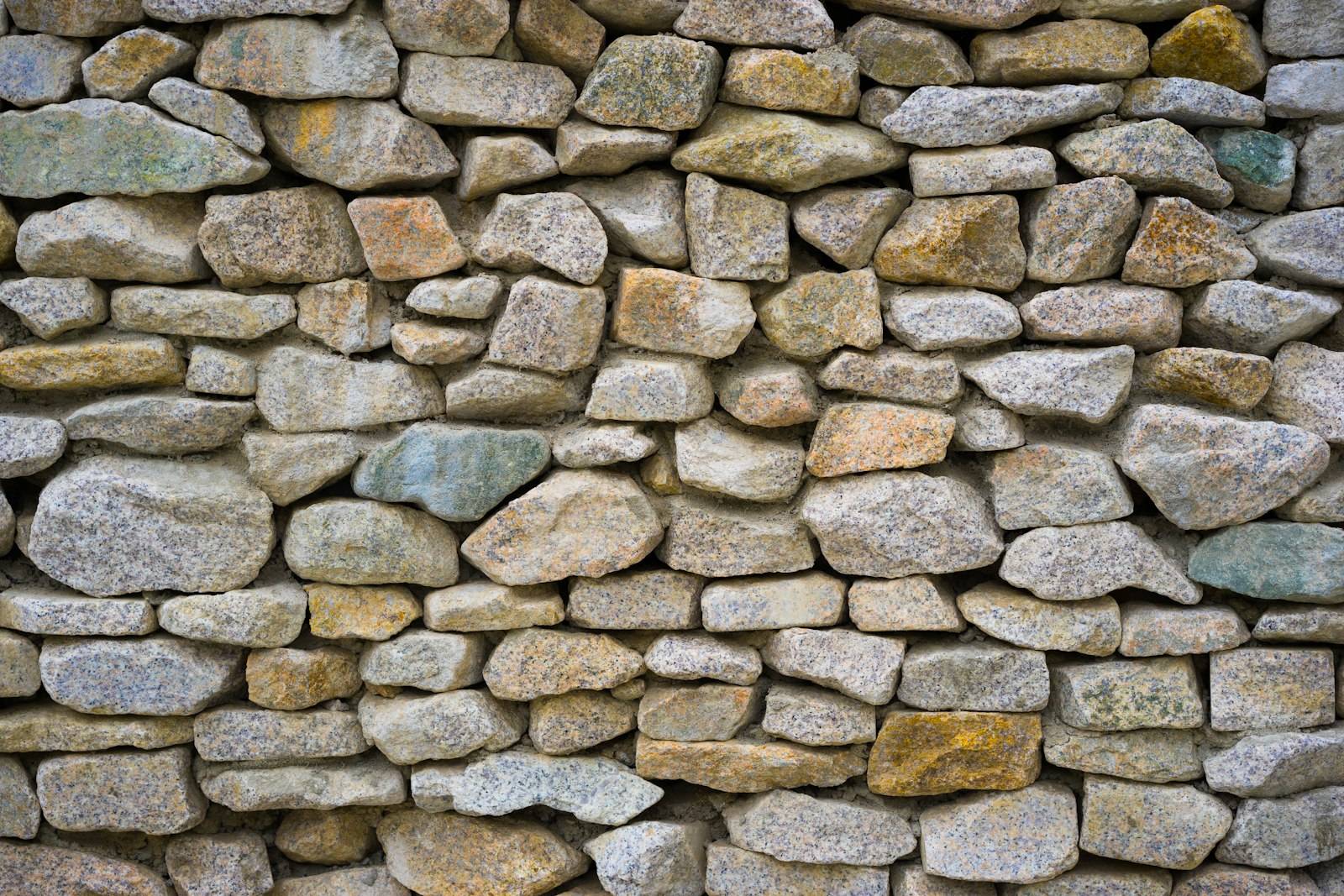 Close-up of a fieldstone wall built from rounded stones of mixed colors